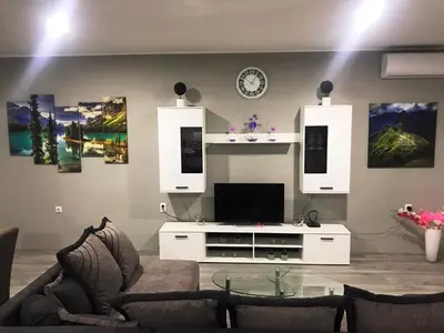 a living room with a couch and a tv at Niš Apartman Lux in Niš