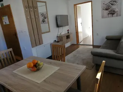 a living room with a table with a bowl of fruit on it at Apartmani & SPA Matin Breg in Jošanička Banja