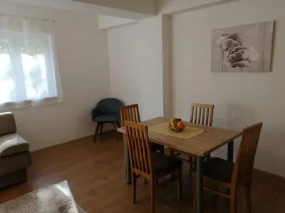 a dining room with a wooden table and chairs at Apartmani & SPA Matin Breg in Jošanička Banja