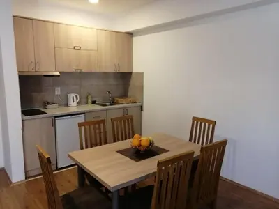 a kitchen with a table with a bowl of fruit on it at Apartmani & SPA Matin Breg in Jošanička Banja