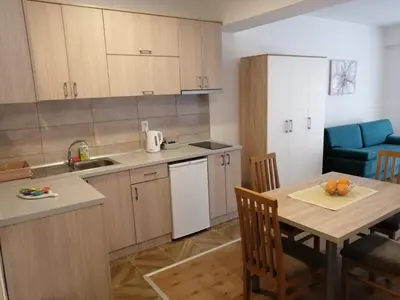 a kitchen with a table and a dining room at Apartmani & SPA Matin Breg in Jošanička Banja