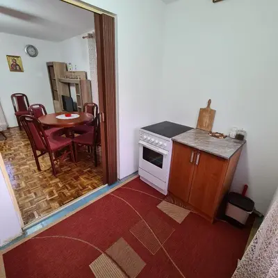a small kitchen with a table and a stove at Apartmani Sunčev breg Vlasinsko jezero in Surdulica