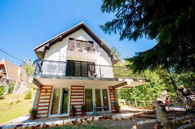 a white house with a balcony on top of it at Apartmani Sunčev breg Vlasinsko jezero in Surdulica