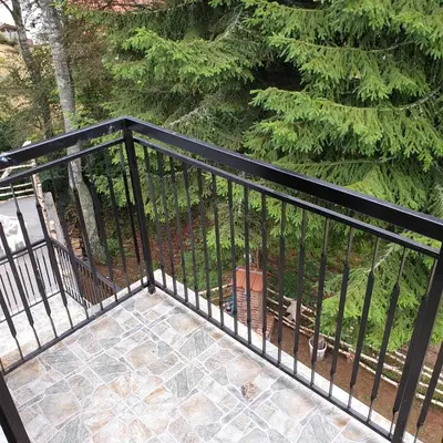 a black railing on a balcony with a bench at Apartmani Sunčev breg Vlasinsko jezero in Surdulica
