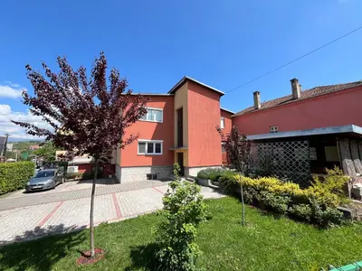 a red house with a tree in the yard at Smestaj Katarina in Soko Banja