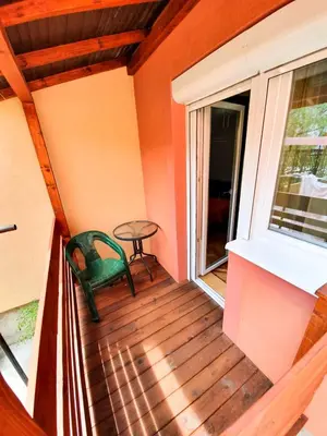 a balcony with a green chair and a table at Smestaj Katarina in Soko Banja