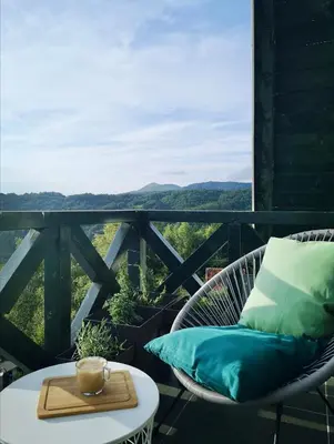 a table and chairs on a balcony with a view at Hiona Apartment in Kopaonik