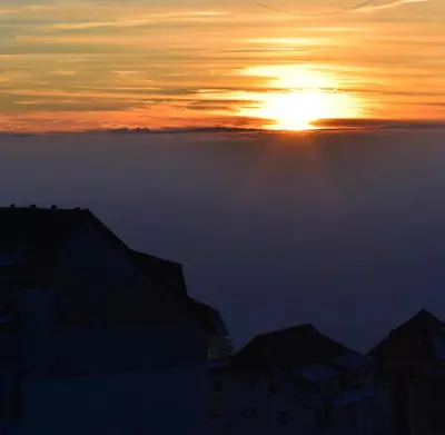 a sunset with the sun rising above the clouds at Hiona Apartment in Kopaonik
