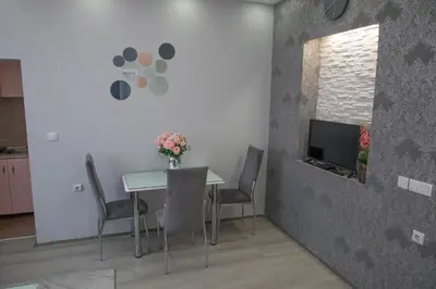 a dining room with a table and chairs and a tv at DIS apartman 1 in Kruševac