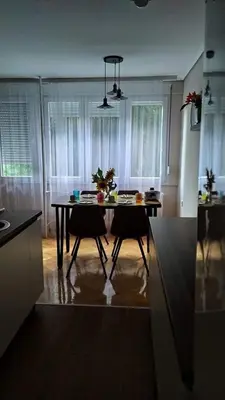 a kitchen with a table and two chairs in a room at Duka Apartment in Niš
