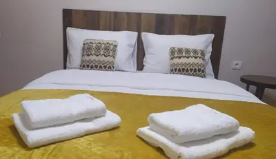 a bed with white towels on top of it at Duka Apartment in Niš