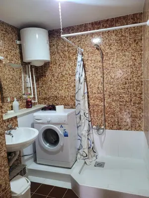 a bathroom with a washing machine and a sink at Duka Apartment in Niš