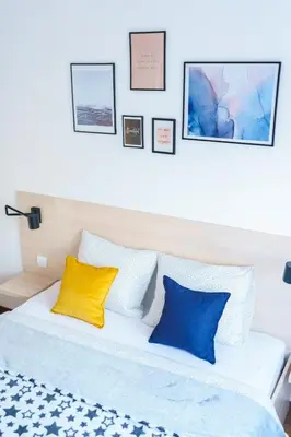 a bedroom with a bed with blue and yellow pillows at Apartments Karamarković 1 in Vrnjačka Banja