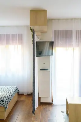 a bedroom with a bed and a flat screen tv at Apartments Karamarković 1 in Vrnjačka Banja