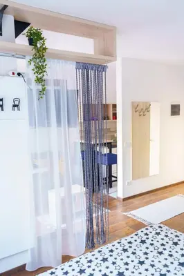 a living room with a curtain and a table at Apartments Karamarković 1 in Vrnjačka Banja