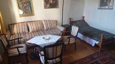 a living room with a couch and a table with chairs at Garičkina kuća in Pirot