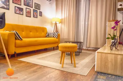 a living room with a yellow couch and a stool at Sunset Vrnjačka Banja in Vrnjačka Banja