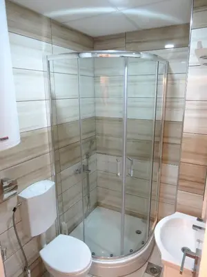 a bathroom with a shower with a toilet and a sink at Sunset Vrnjačka Banja in Vrnjačka Banja