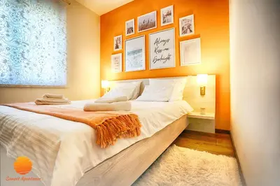 a bedroom with a large bed with an orange wall at Sunset Vrnjačka Banja in Vrnjačka Banja