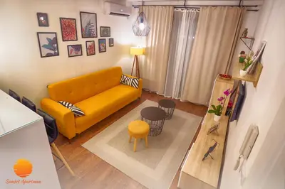 a living room with a yellow couch and a table at Sunset Vrnjačka Banja in Vrnjačka Banja
