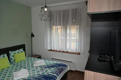 a small bedroom with a bed and a window at Sneznik Palace in Vrnjačka Banja