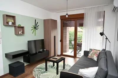 a living room with a couch and a television at Sneznik Palace in Vrnjačka Banja