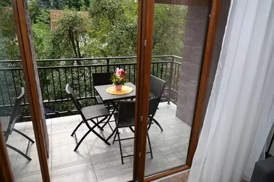 a patio with a table and chairs on a balcony at Sneznik Palace in Vrnjačka Banja