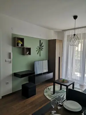 a living room with a television and a table at Sneznik Palace in Vrnjačka Banja