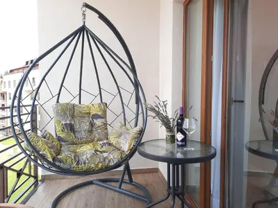 a room with a swing chair and a table at Vistanova Milmari S33 in Kopaonik