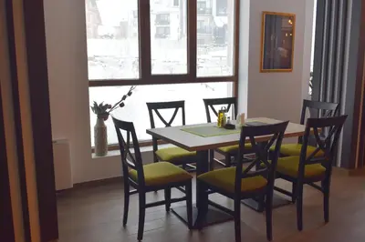 a dining room with a table and chairs and a window at Vistanova Milmari S33 in Kopaonik