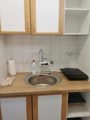 a kitchen counter with a sink and a bottle of soap at Apartman Centar in Aleksandrovac