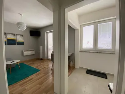 a living room with a table and a green rug at Apartment 13 in Vrnjačka Banja