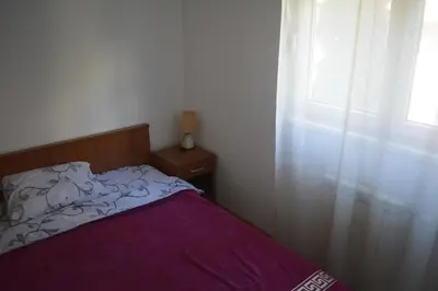 a bed with a purple blanket and a window at Apartman Pirot in Pirot