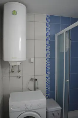 a bathroom with a washing machine and a toilet at Apartman Pirot in Pirot