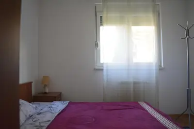 a bedroom with a purple bed and a window at Apartman Pirot in Pirot