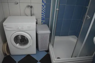 a small bathroom with a washing machine and a shower at Apartman Pirot in Pirot