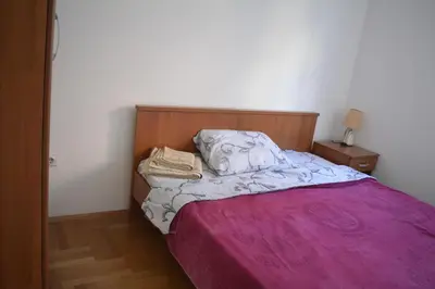 a bedroom with a bed with a pink blanket at Apartman Pirot in Pirot