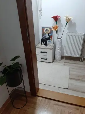 a room with a white dresser and a vase with flowers at Apartman OAZA in Vrnjačka Banja