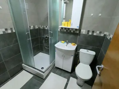 a bathroom with a shower and a toilet and a sink at Apartman OAZA in Vrnjačka Banja