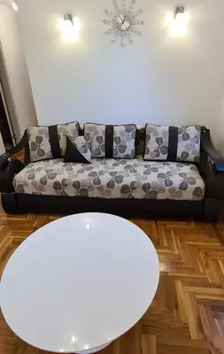 a living room with a couch and a white table at Apartman u Brzecu - Kopaonik in Kopaonik