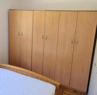 a bedroom with wooden cabinets and a bed at Apartman u Brzecu - Kopaonik in Kopaonik
