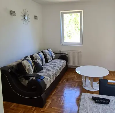 a living room with a couch and a table at Apartman u Brzecu - Kopaonik in Kopaonik