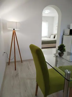 a living room with a green chair and a bedroom at Studio Andrijana Sokobanja in Soko Banja