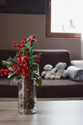 a vase with red berries and christmas decorations on a table at Milmari Friends and Family in Kopaonik