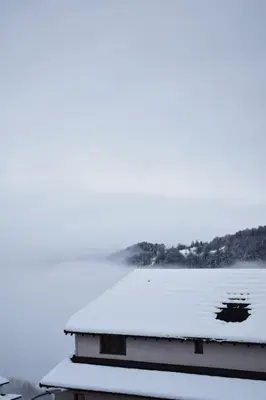 a house with snow on the roof and a lake at Milmari Friends and Family in Kopaonik