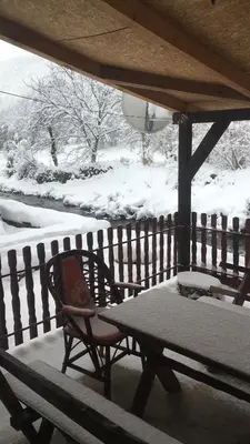a table and a chair on a porch in the snow at Vila Panic in Pirot