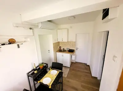 a small apartment with a table and a kitchen at Dvor in Donja Toponica