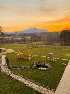 a bench in a field with a mountain in the background at Rtanjska bajka in Boljevac