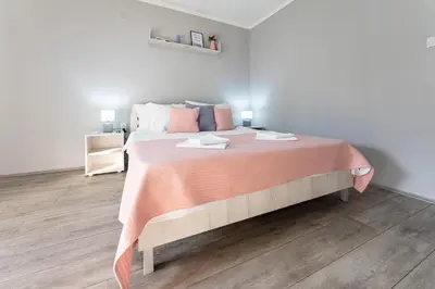 a bedroom with a large bed with a pink blanket at Rtanjska bajka in Boljevac