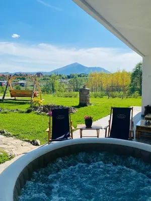 a hot tub in a backyard with two chairs and a table at Rtanjska bajka in Boljevac